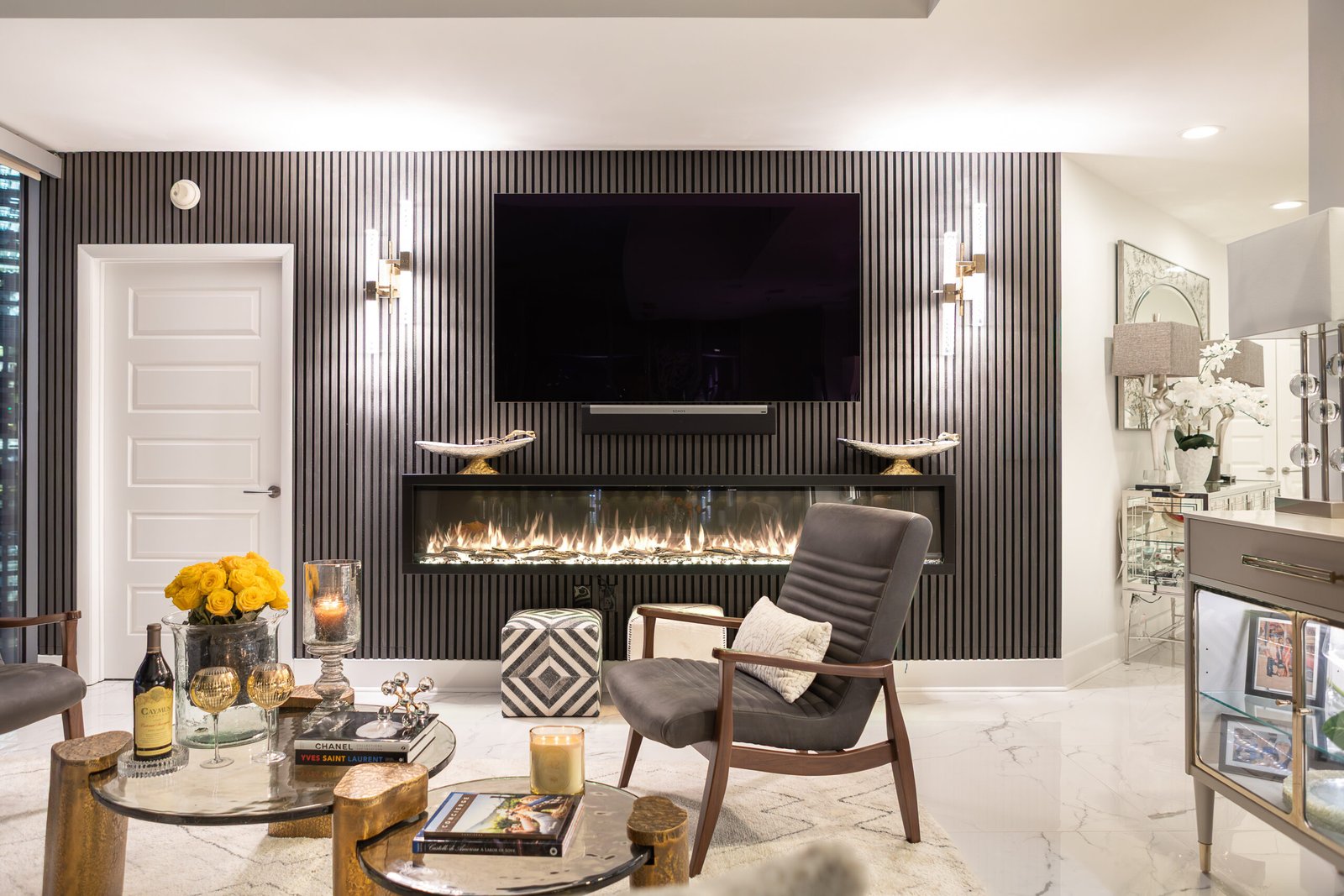 Living room with a fluted feature wall, linear fireplace and lounge chairs