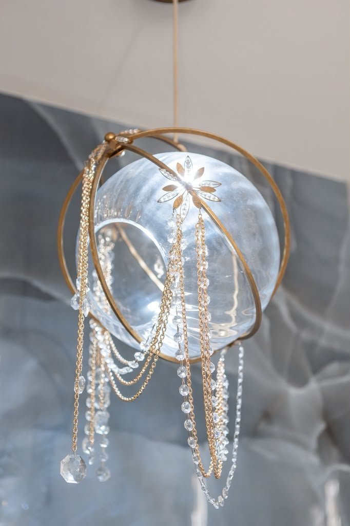 Gold ring pendant against a blue onyx wall