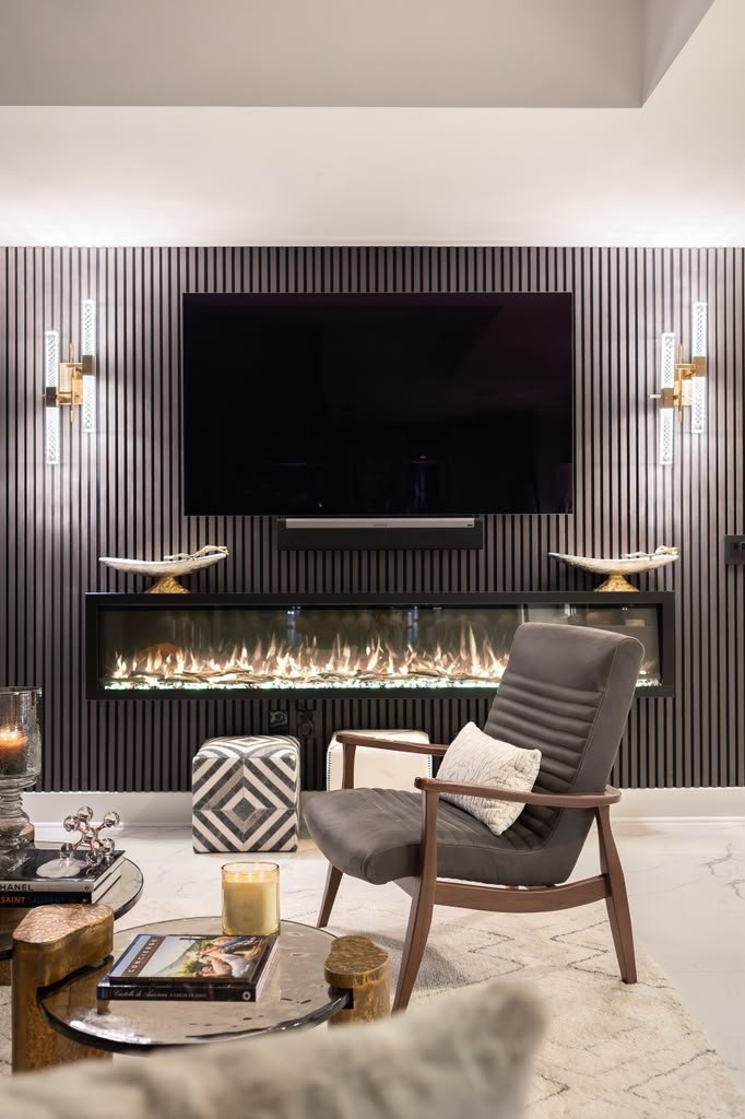Fluted fireplace wall with brass sconces on either side