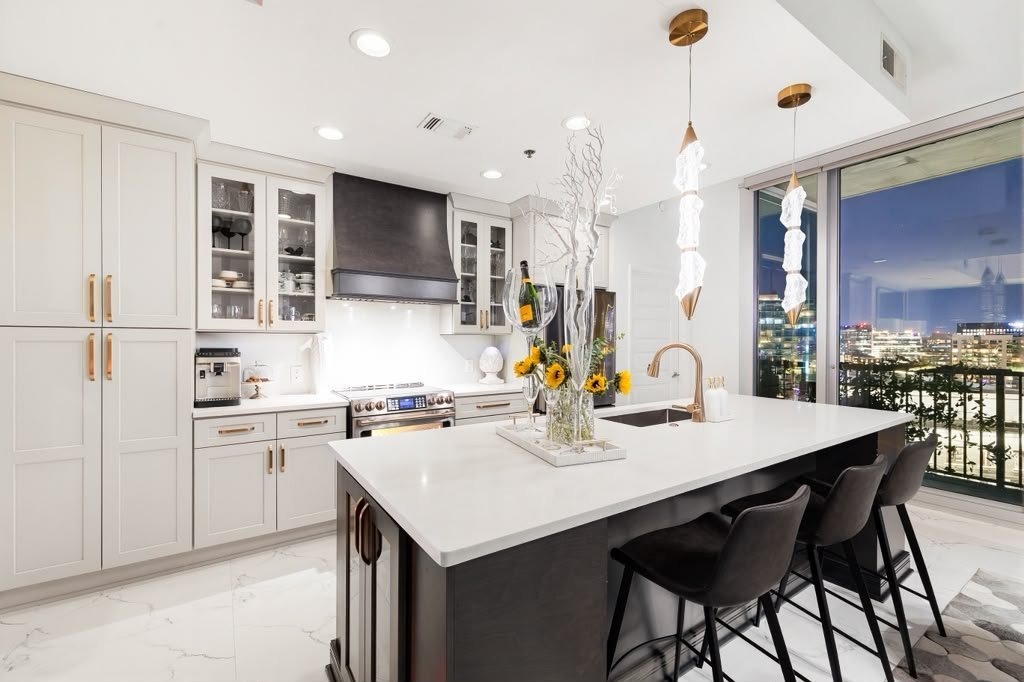 Kitchen with a marble waterfall island and brass details