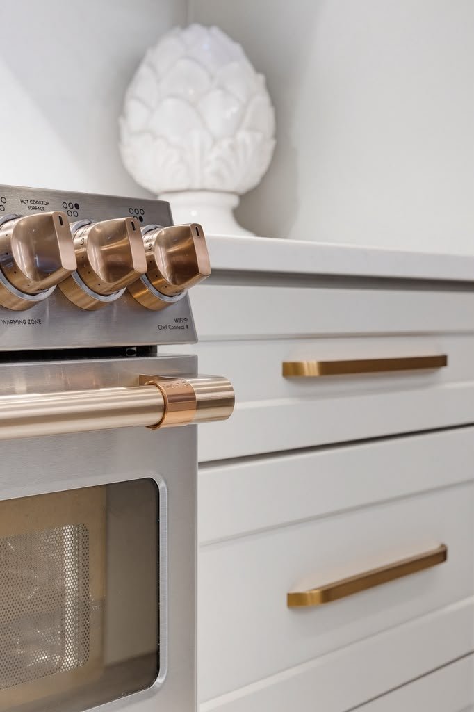 White range with copper knobs and a brass handle