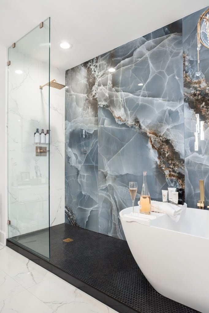 Glass shower with black penny tile in the primary bathroom