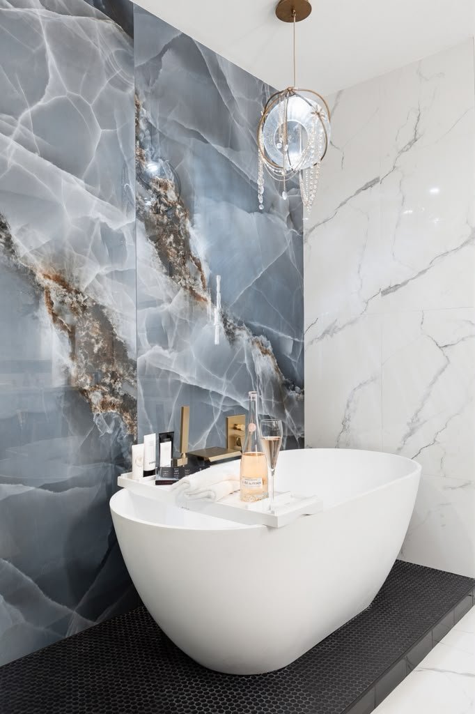Primary bathroom with a blue onyx wall and sculptural freestanding tub