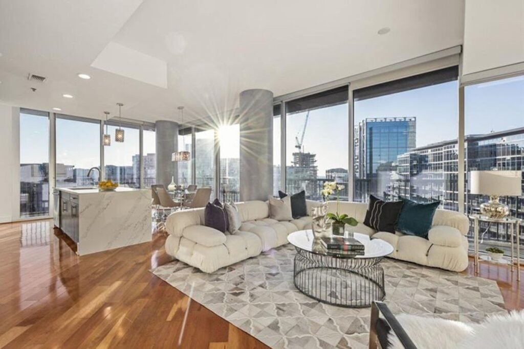 Penthouse living room before the redesign, with hardwood floors and a white bouclé sofa