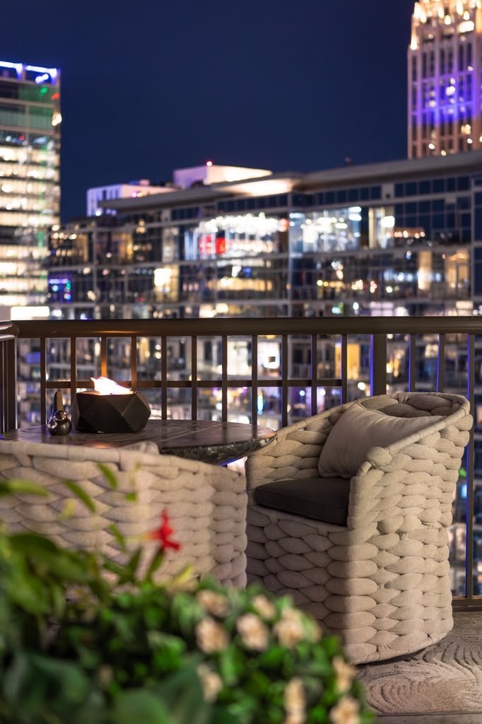 Terrace with woven chairs, planting and city lights